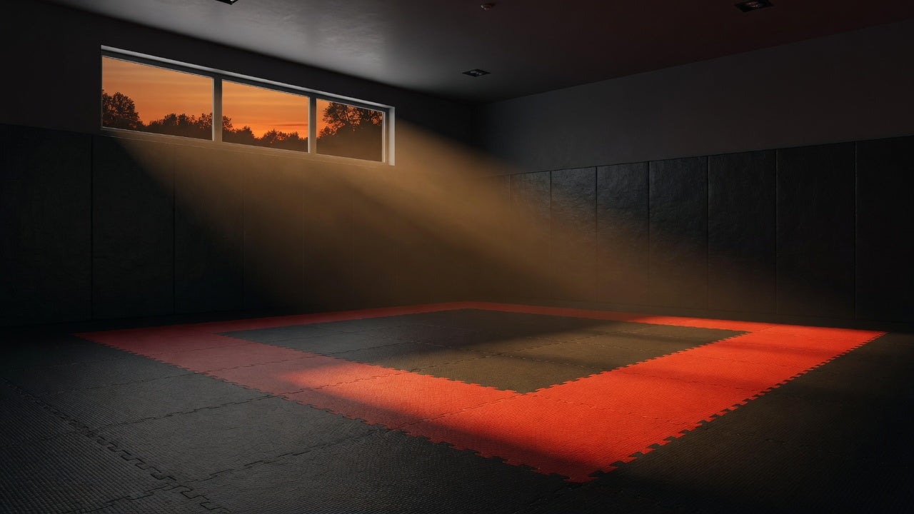 Empty dojo at dusk with red and charcoal tatami puzzle mats
